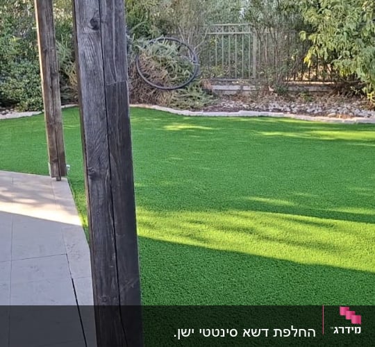התקנת דשא סינטטי בחצר בית פרטי לצד מרפסת מרוצפת